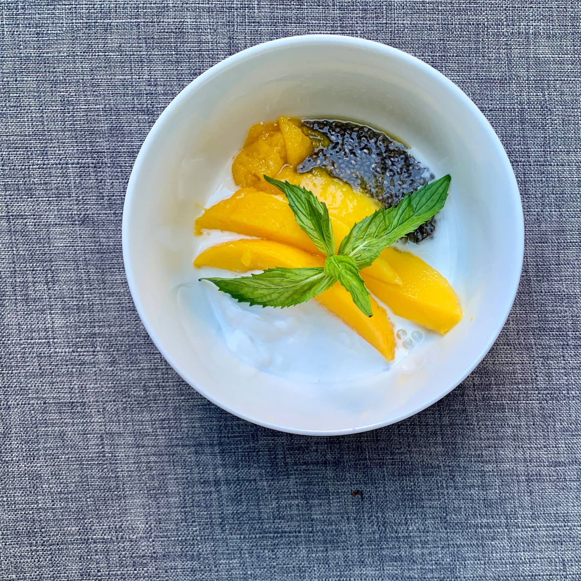 easy healthy breakfast of mango coconut mint and chia in a white bowl